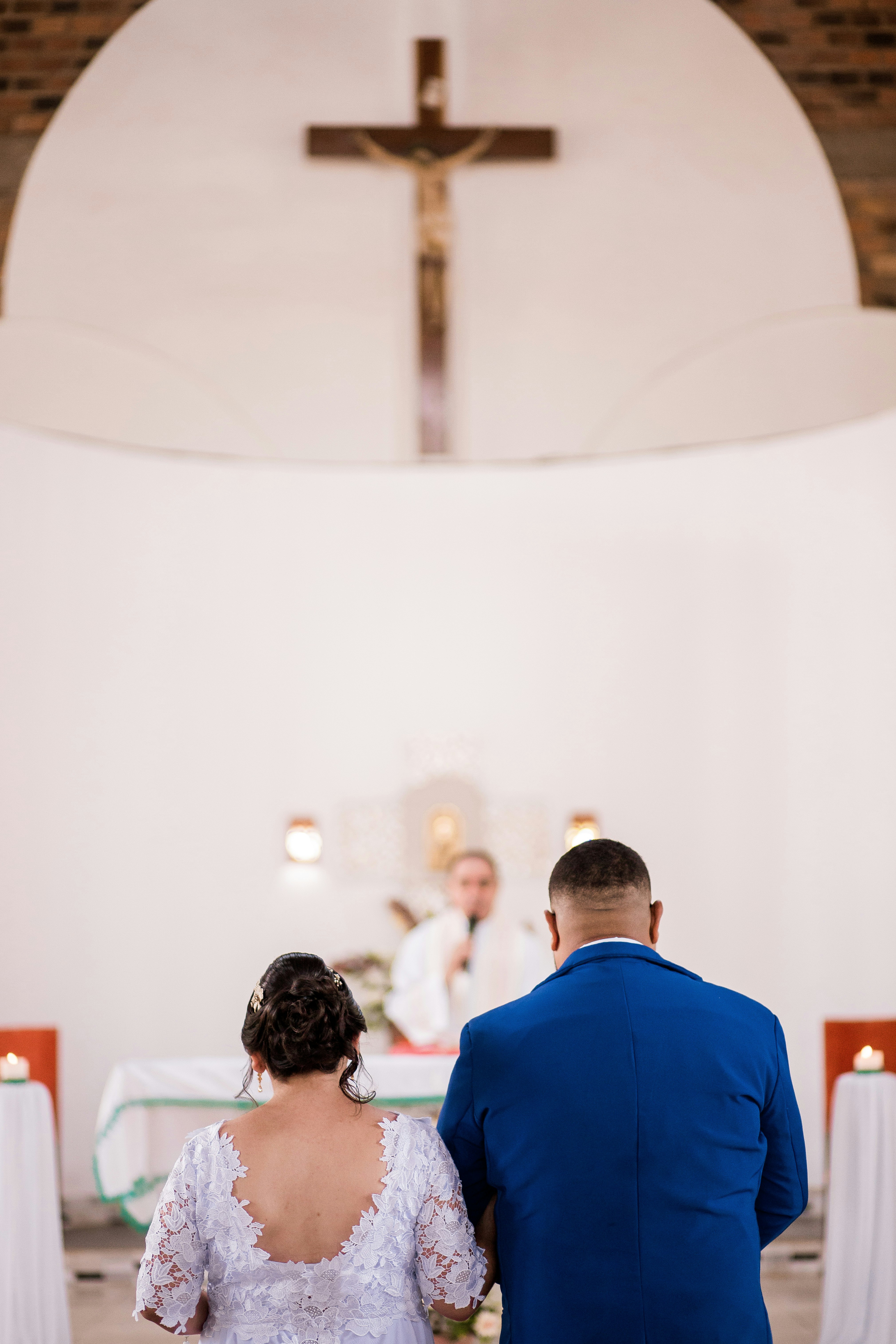 man in blue suit standing in front of woman in white shirt